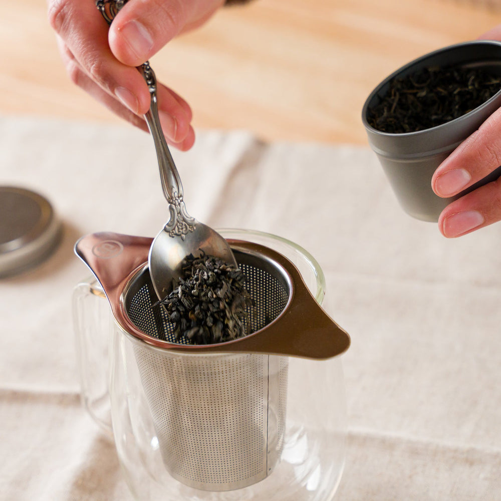 Putting loose tea leaves into the Mesh Tea Infuser Basket